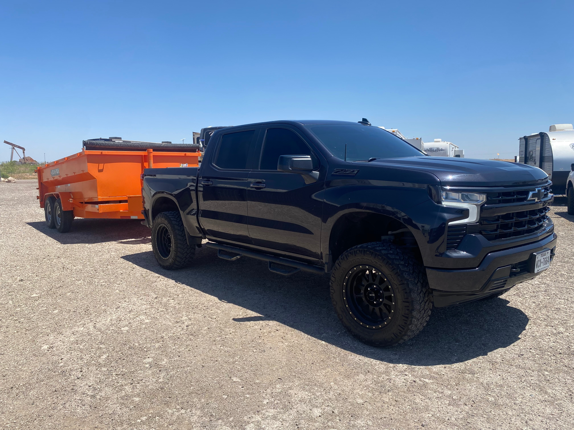 Early Bird Texan Services truck and orange dump trailer ready for a hauling job in West Texas
