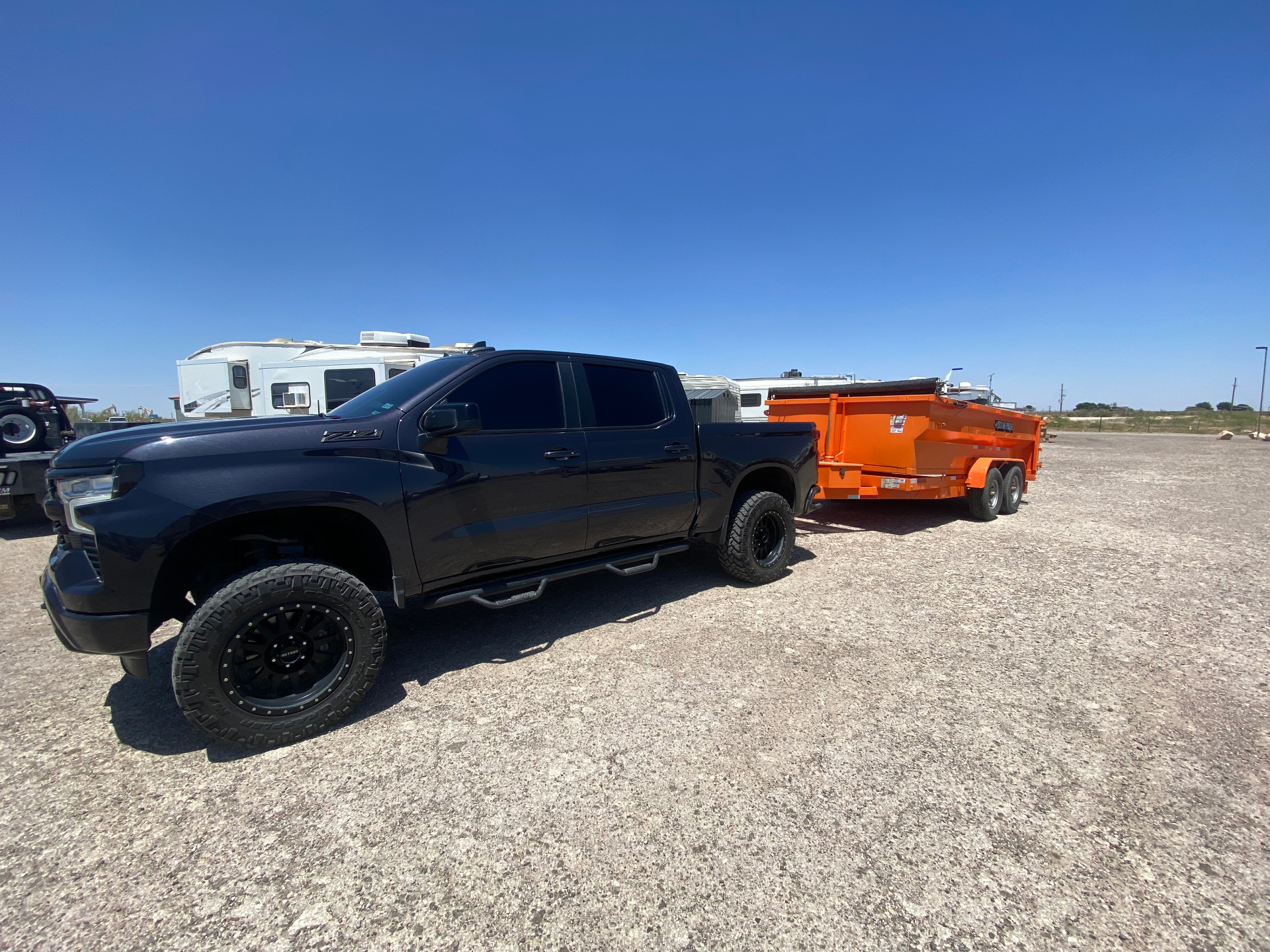 Side view of the Early Bird Texan Services hauling truck and dump trailer